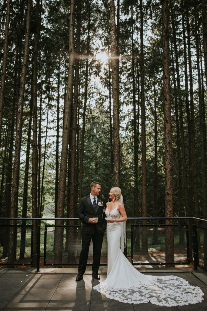 Bride and groom sharing a romantic moment at Shepherd’s Hollow Golf Club with a picturesque forest backdrop