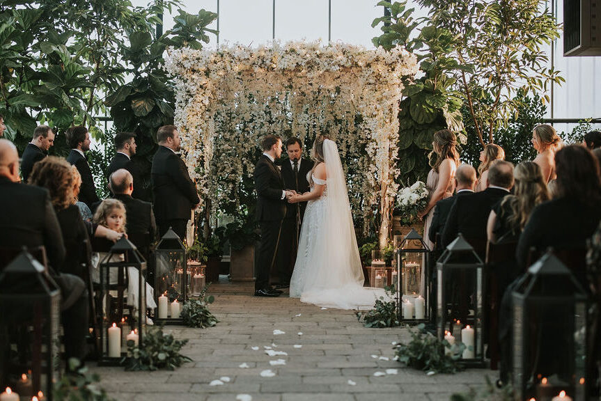 Bride and groom exchanging vows surrounded by the vibrant greenery at Planterra Conservatory