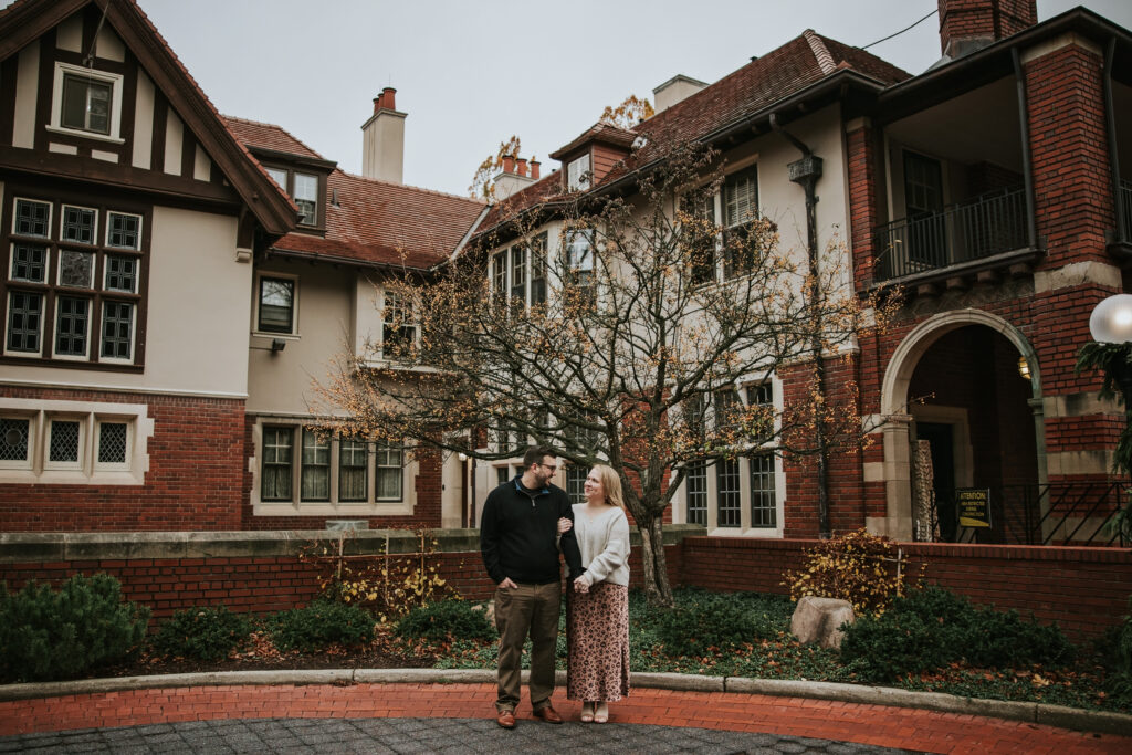 Couple posing together in front of the historic Cranbrook House.