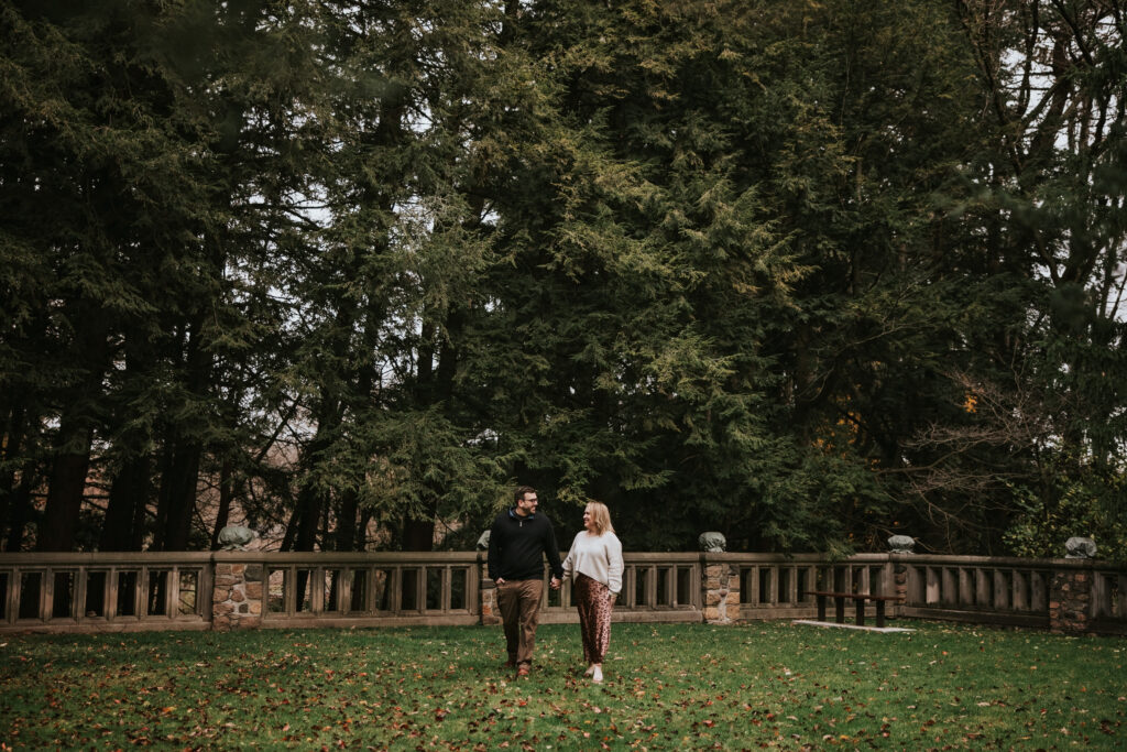 Couple laughing under tall trees at Cranbrook House and Gardens.