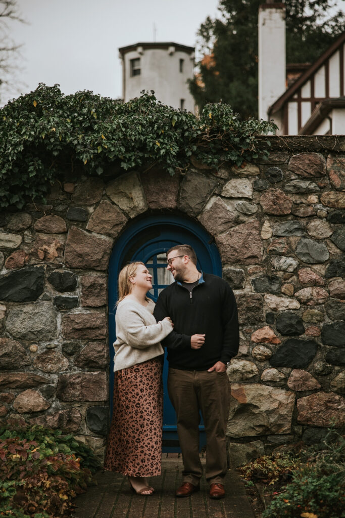 Couple embracing in front of the stone garden walls at their Cranbrook engagement session.  