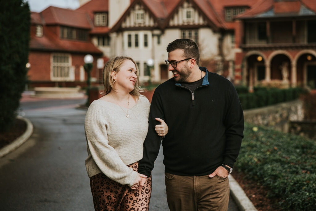 Couple smiling at each other in front of Cranbrook House and Gardens.