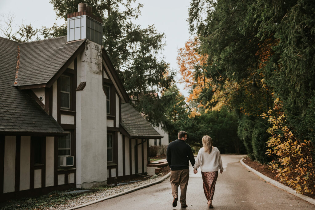 Couple walking hand-in-hand through a tree-lined path at Cranbrook Gardens.