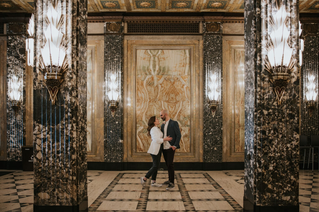 Fisher Building engagement session featuring a couple embracing by the marble columns.