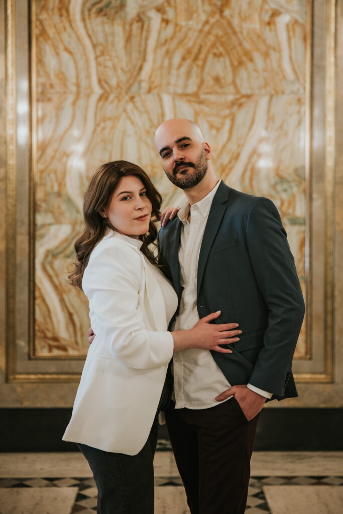 Couple sharing a moment under the intricate ceiling of the Fisher Building in Detroit.