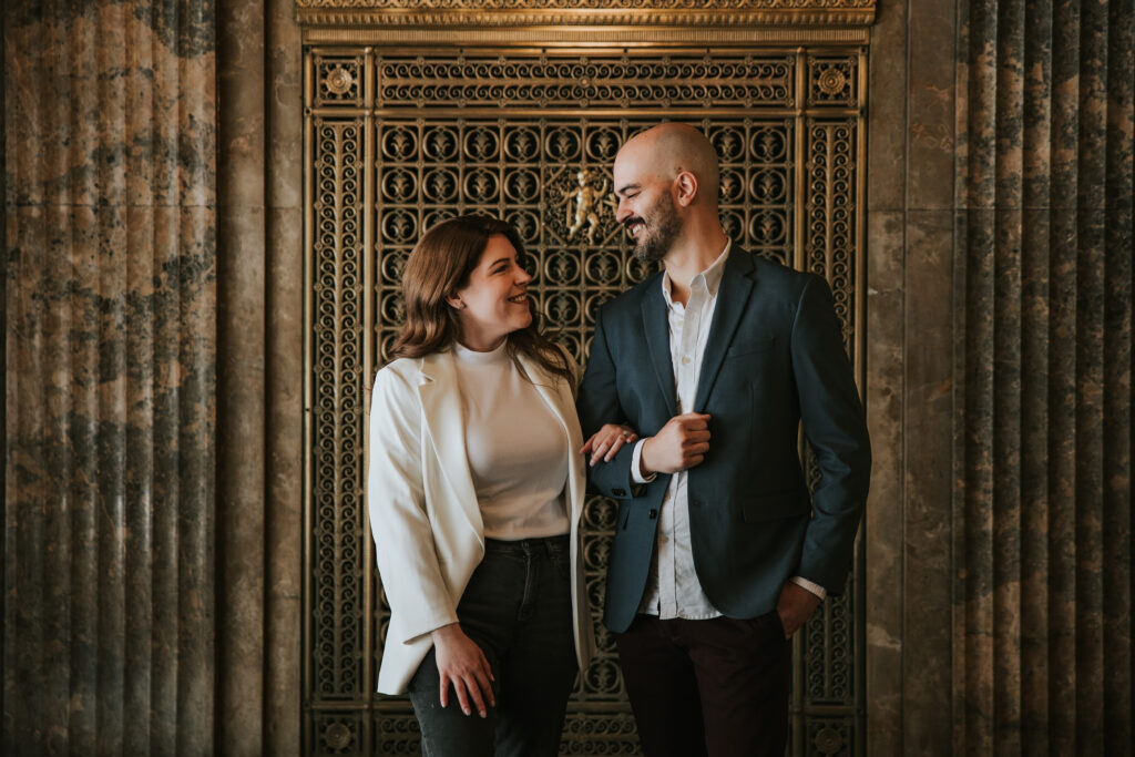 Detroit couple laughing in the grand lobby of the Fisher Building.