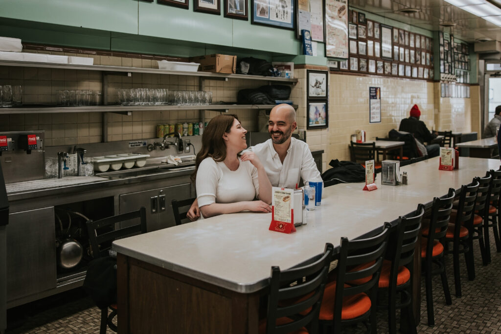 Couple enjoying Detroit’s iconic Coney Island hot dogs during their engagement shoot at Lafayette Coney Island.