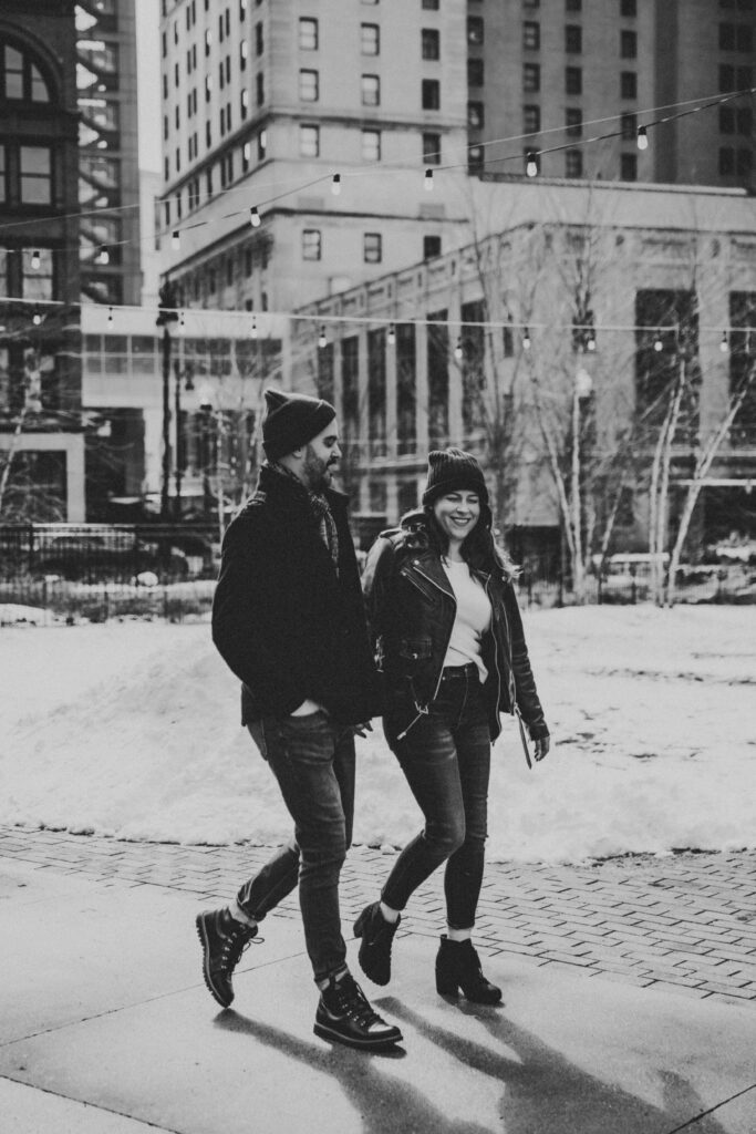 Couple bundled up in winter coats during their Detroit engagement session downtown.