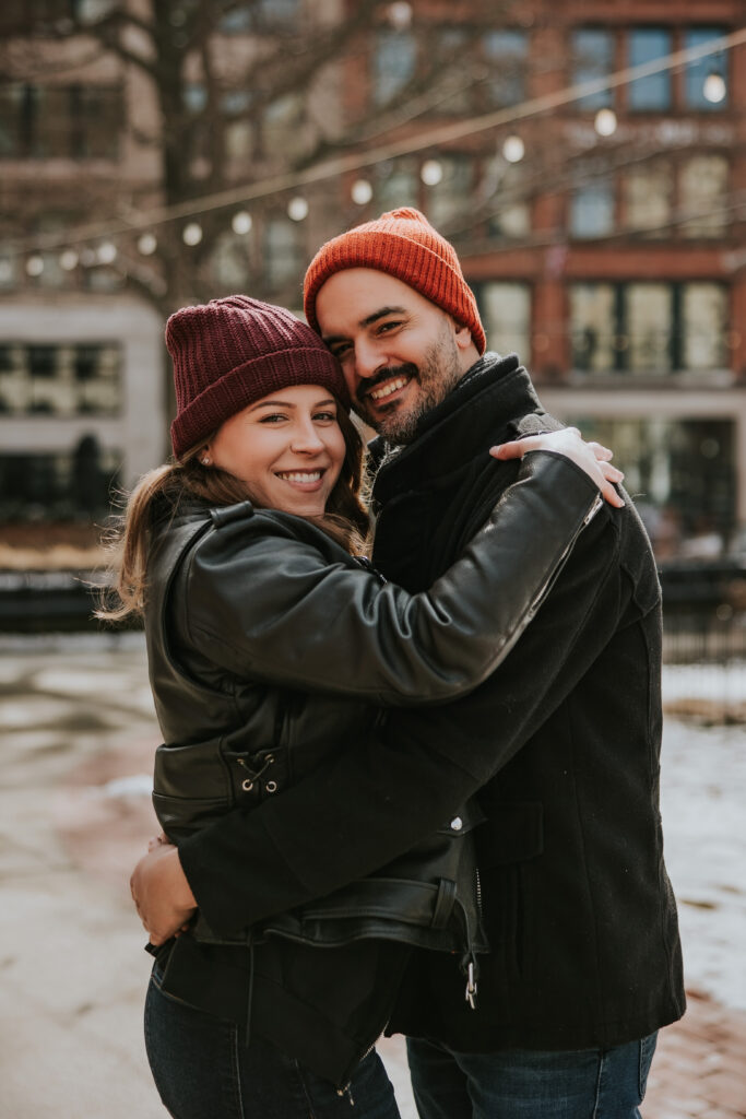 Detroit Winter Engagement Session couple smiling at camera in downtown Detroit. 