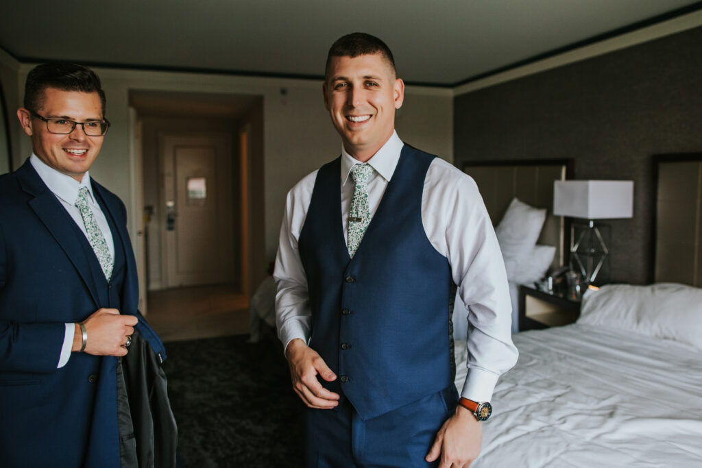 Groom adjusting his suit before the ceremony at Lovett Hall, Henry Ford Museum, ensuring a perfect look for his wedding day.