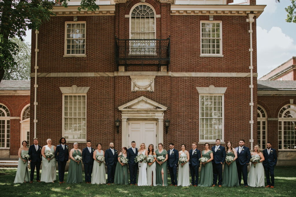 Bridal party posing outside Lovett Hall at Henry Ford Museum, celebrating Amanda and Mitchell’s wedding day.