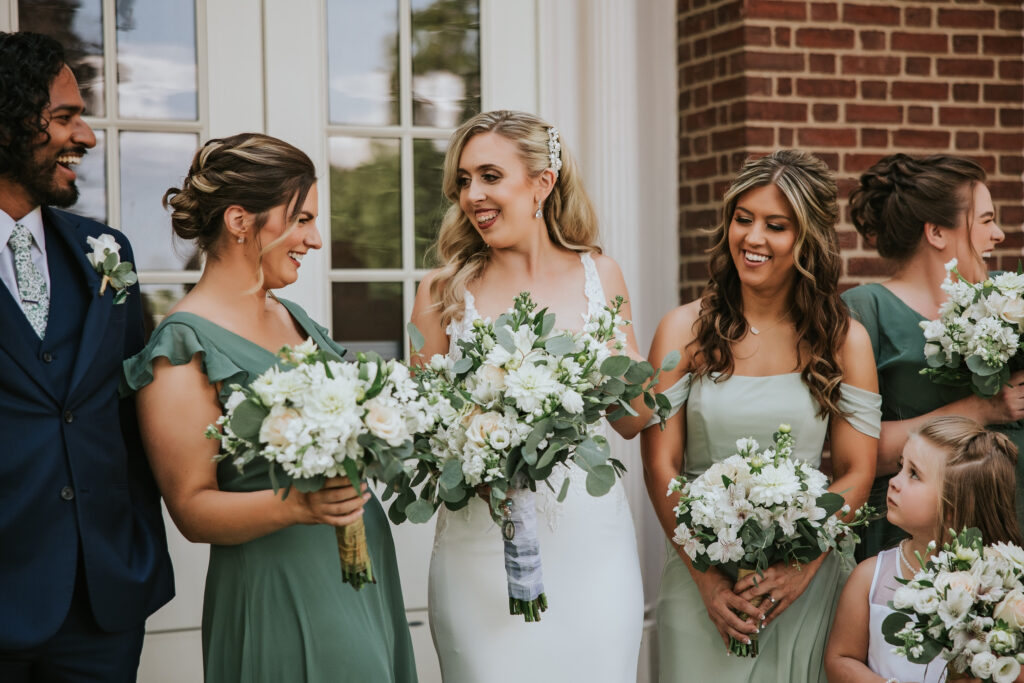 Bridal party laughing together at Lovett Hall, sharing a joyful moment outside before the ceremony begins.