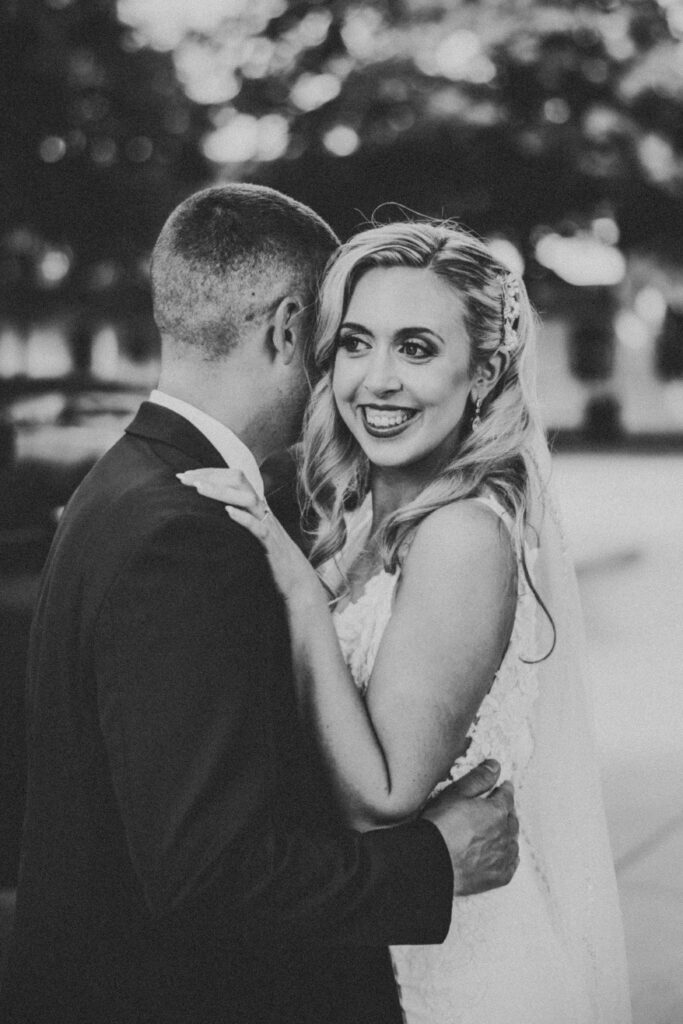 Romantic moment of bride and groom posing in front of Greenfield Village’s charming historical backdrop.