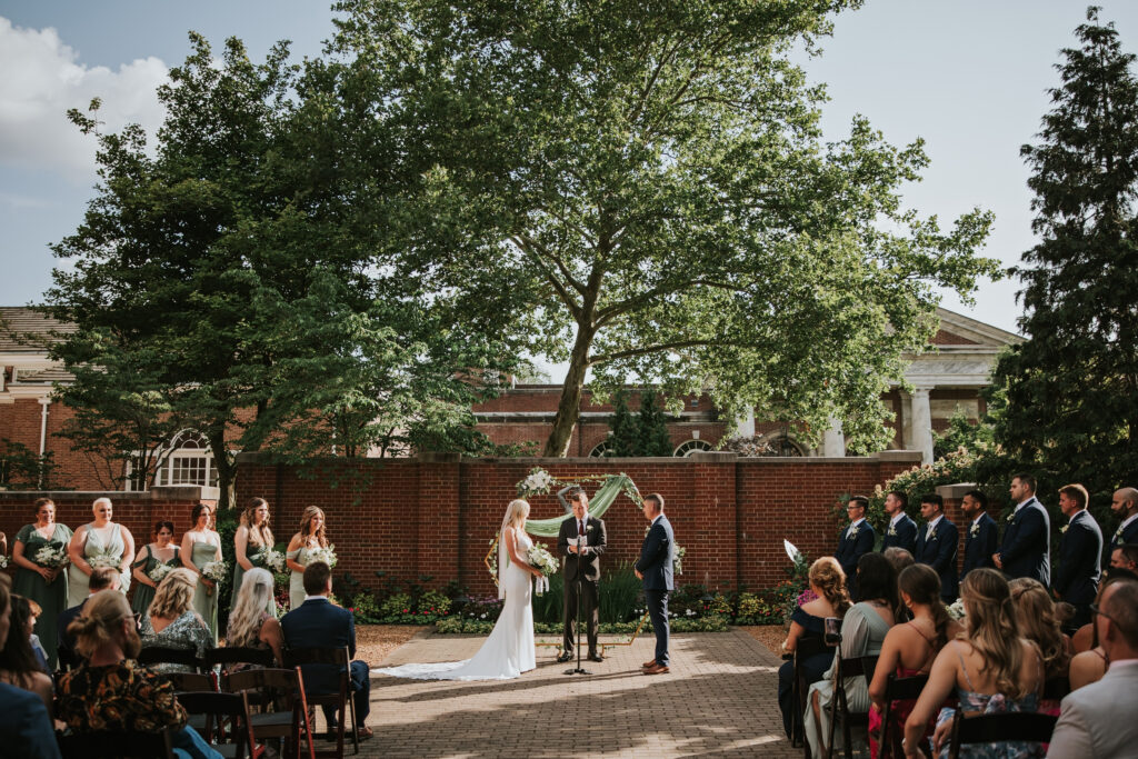 Bride and groom exchanging vows during their intimate wedding ceremony at Lovett Hall, Henry Ford Museum.