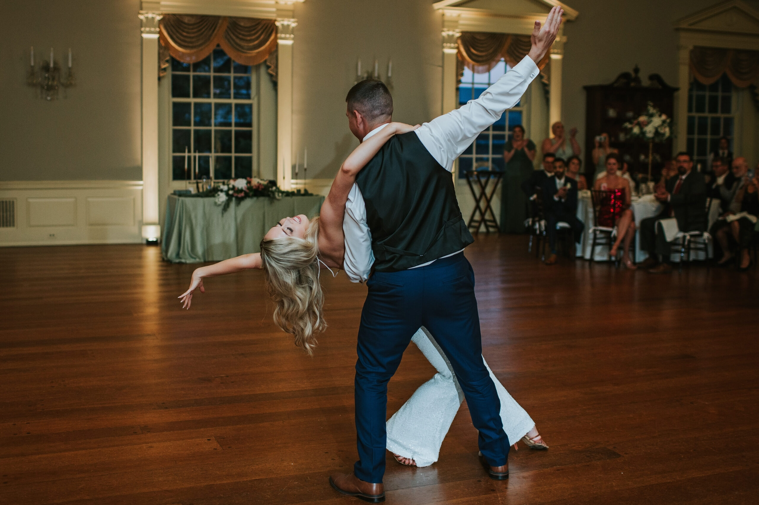 First dance of Amanda and Mitchell at Lovett Hall, Henry Ford Museum, surrounded by guests in an elegant ballroom.