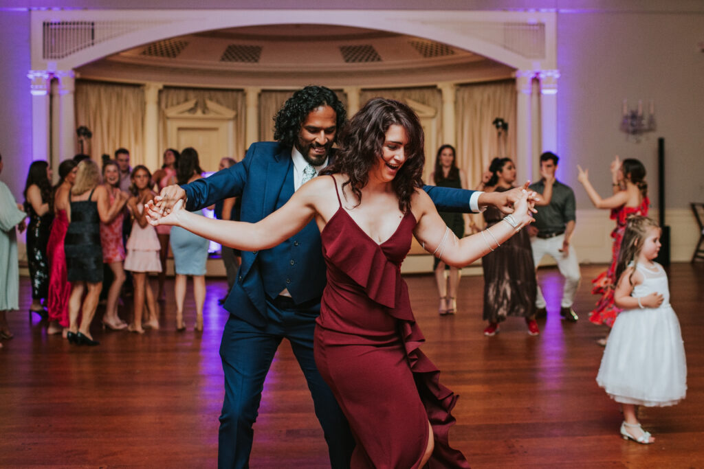 Guests dancing and enjoying themselves at the lively wedding reception at Lovett Hall, Henry Ford Museum.