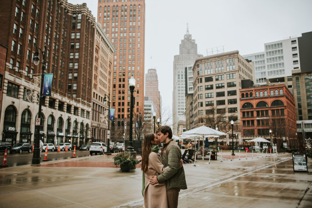 Couple embracing the rain in Capitol Park for their Detroit engagement session.