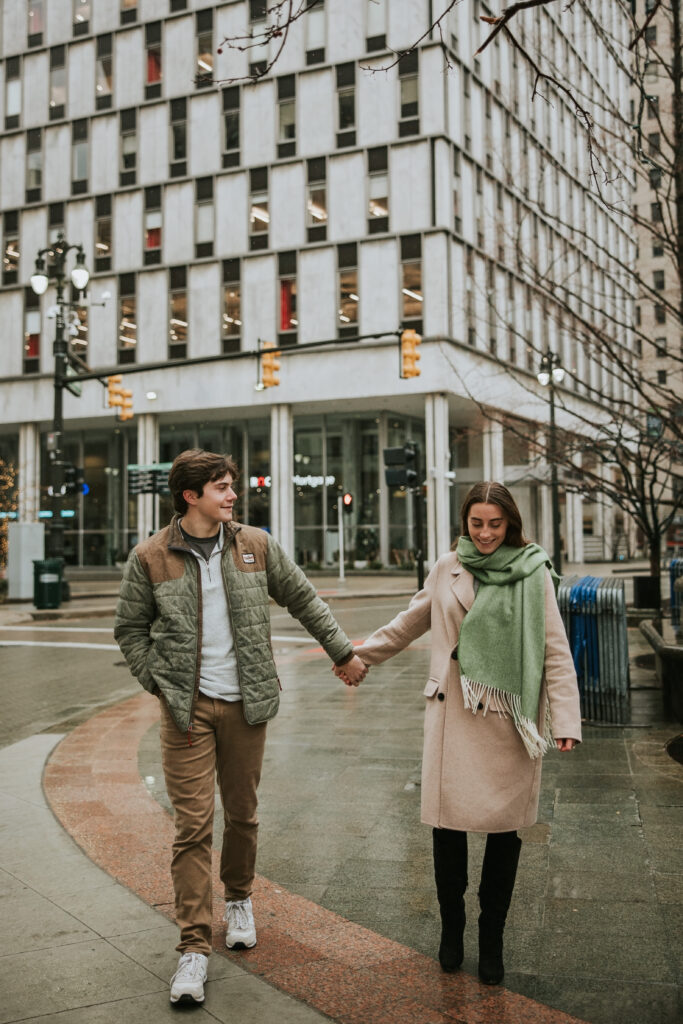 Embracing the weather: couple strolling in the rain near Cadillac Square Markets.