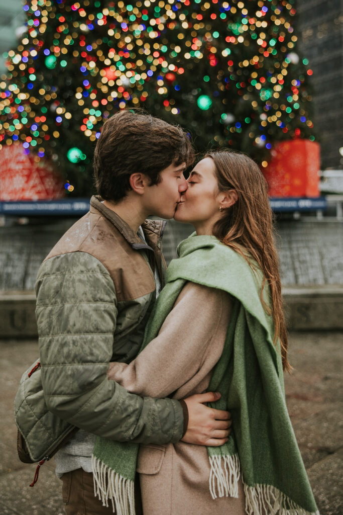 Engagement photo in the rain with downtown Detroit’s festive atmosphere at Campus Martius.