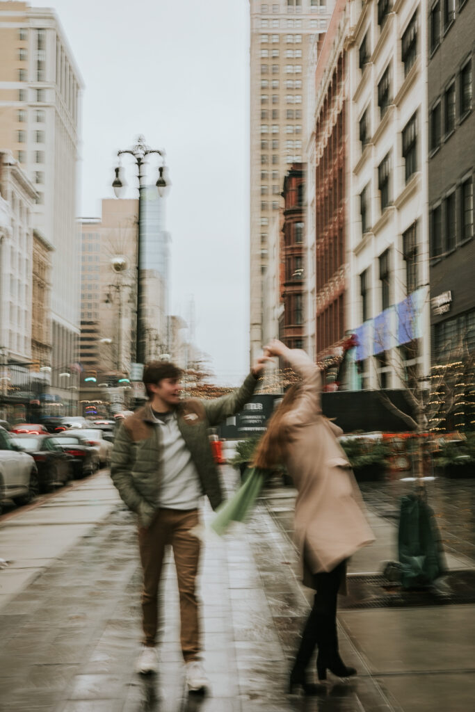 Bride and groom-to-be sharing a playful moment in the rain on Woodward Avenue.