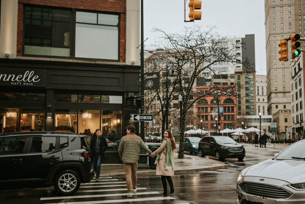 Couple in the rain with Detroit’s vibrant architecture in the background.