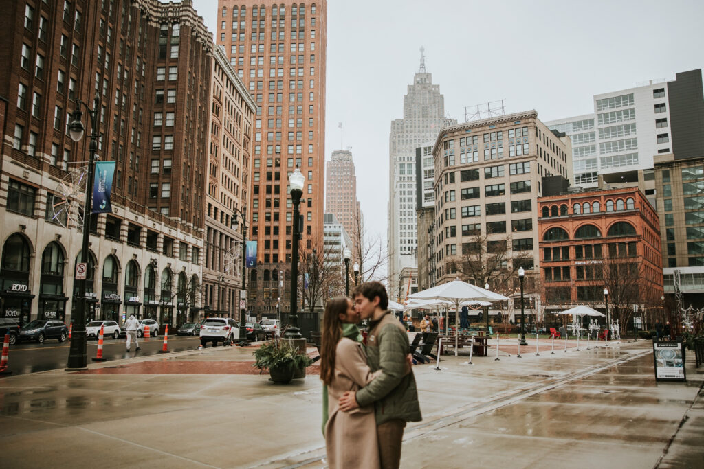 Couple embracing each other with love and joy on a rainy engagement session in Detroit.