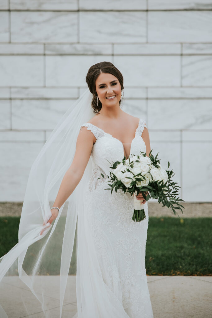 Bride showcasing her matching veil and dress in front of the Detroit Institute of Arts | Wedding Planning Tips