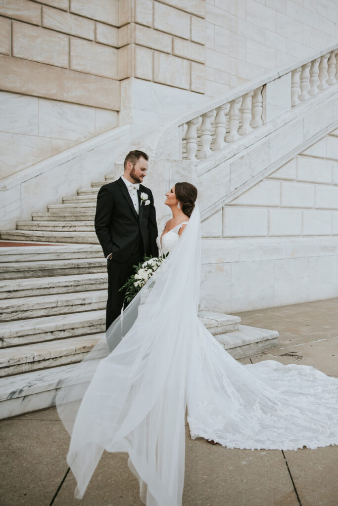 Bride and groom at the Detroit Institute of Arts, highlighting the bride’s matching veil and wedding dress | Wedding Planning Tips