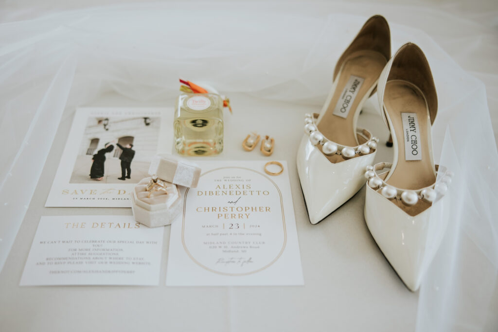 Flat lay of wedding invitations, rings, and florals in soft, elegant tones | Wedding Planning Tips