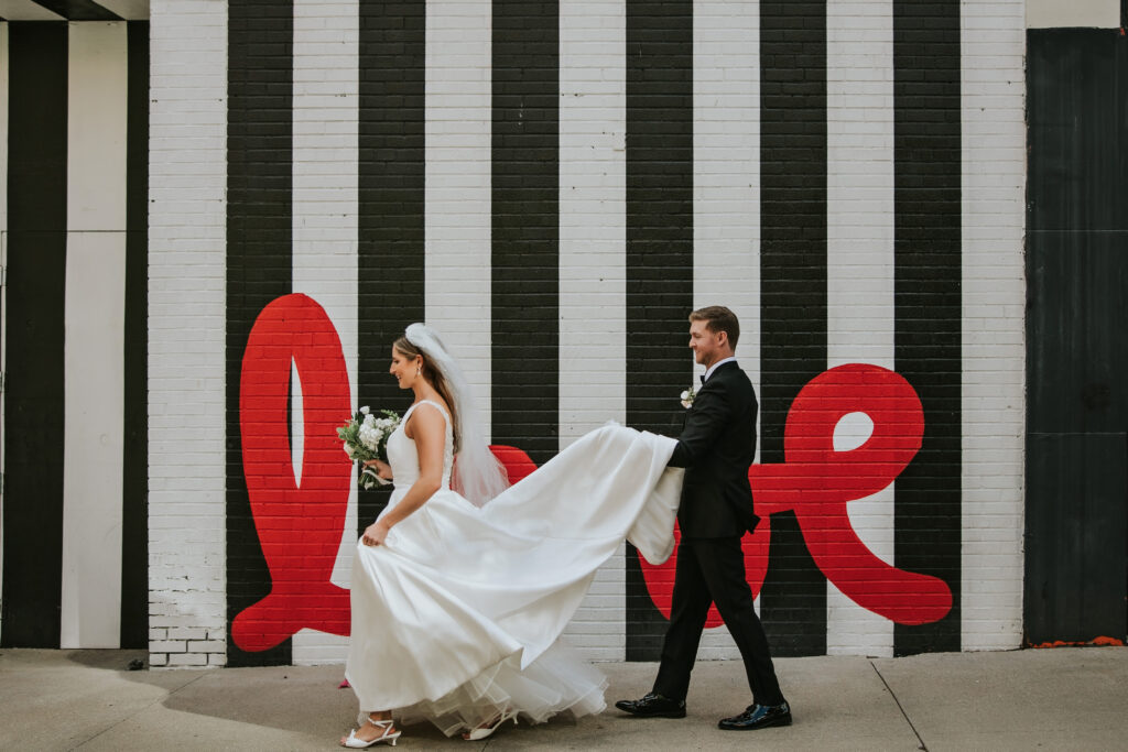 Bride and groom walking through downtown Detroit for wedding portraits after their ceremony