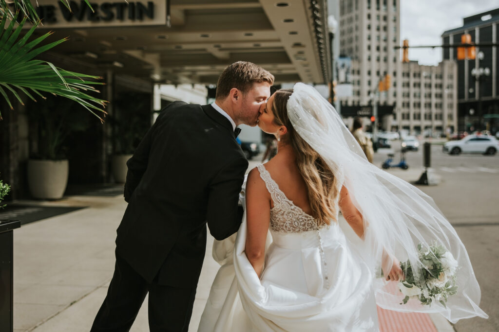 Bride and groom share a kiss in front of their Westin Book Cadillac wedding