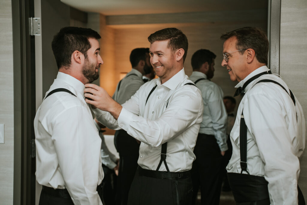 Groom helping his groomsmen get ready at the Westin Book Cadillac hotel