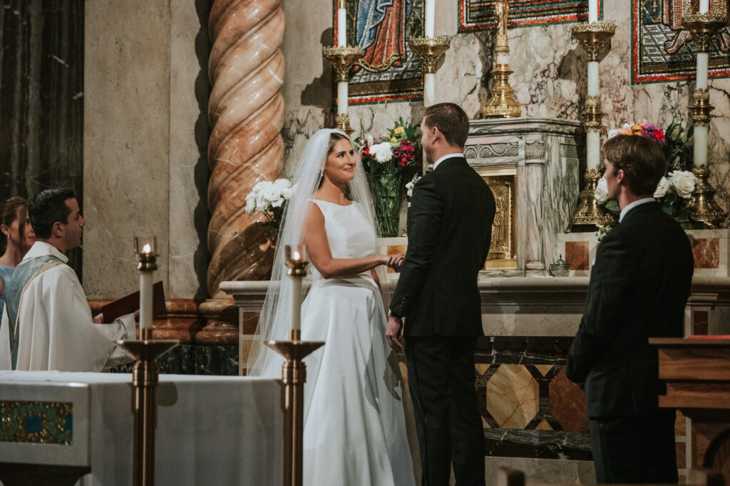 Bride and groom standing hand-in-hand at St. Aloysius Church during their wedding ceremony