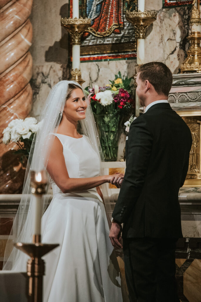 Bride and groom smiling at each other during their wedding ceremony at St. Aloysius Church