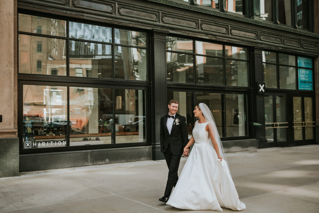 Couple walking hand in hand at Capitol Park in Detroit during their wedding portrait session