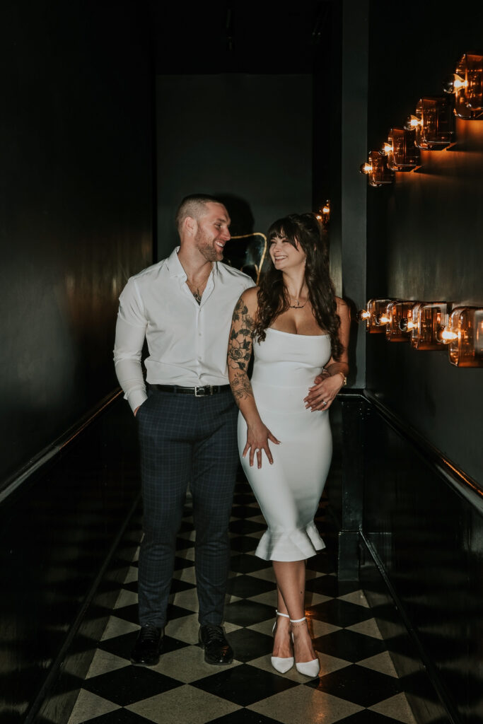 Chic portrait featuring a couple's loving gaze during a Candy Bar Detroit Engagement session set in a trendy Detroit lounge.