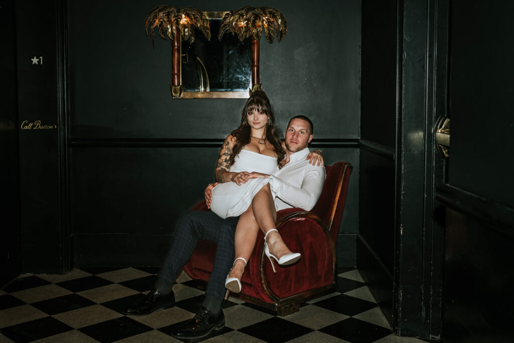 Romantic portrait of a couple set against an urban art backdrop at a Candy Bar Detroit Engagement session in a sleek Detroit lounge.