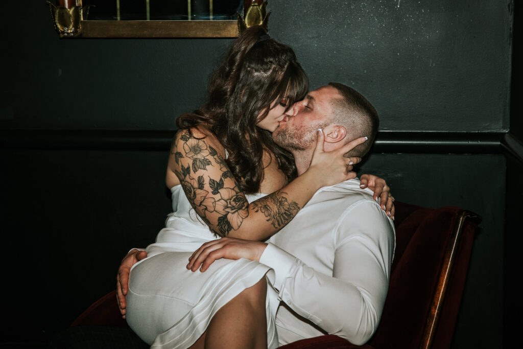 Elegant couple enjoying a moment of intimacy during a Candy Bar Detroit Engagement session in a sophisticated Detroit lounge.