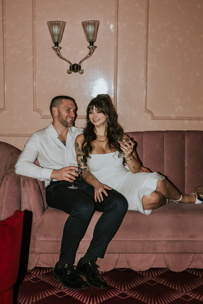 Candid shot of a couple exploring the chic decor of Candy Bar Detroit during an engagement session in a downtown Detroit lounge.