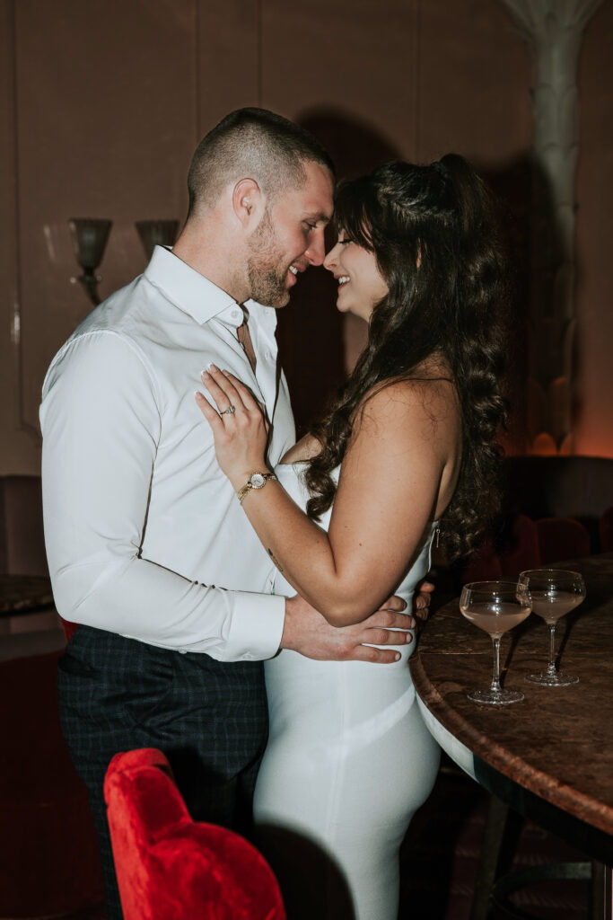 Playful image capturing a couple’s laughter among retro-chic details during a Candy Bar Detroit Engagement session in Detroit.