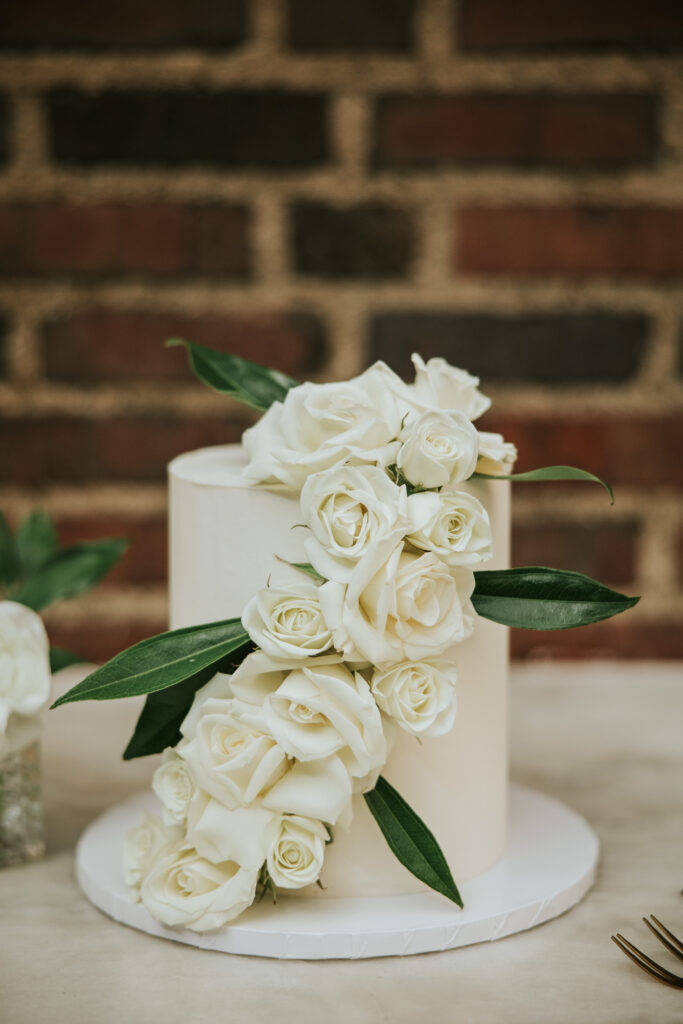 Close-up of the wedding cake with delicate sugar flowers at the reception.