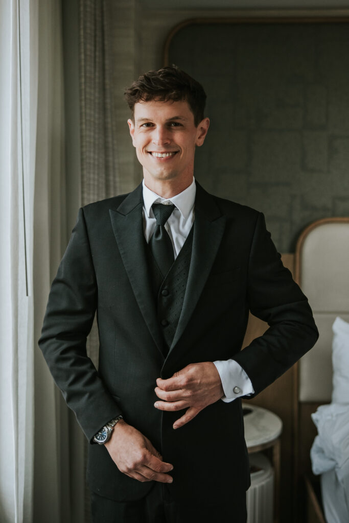 Groom adjusting his suit at the Westin Book Cadillac.