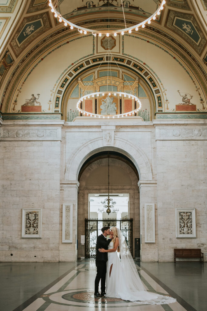 Bride and Groom kissing in the great hall at the Detroit Institute of Arts