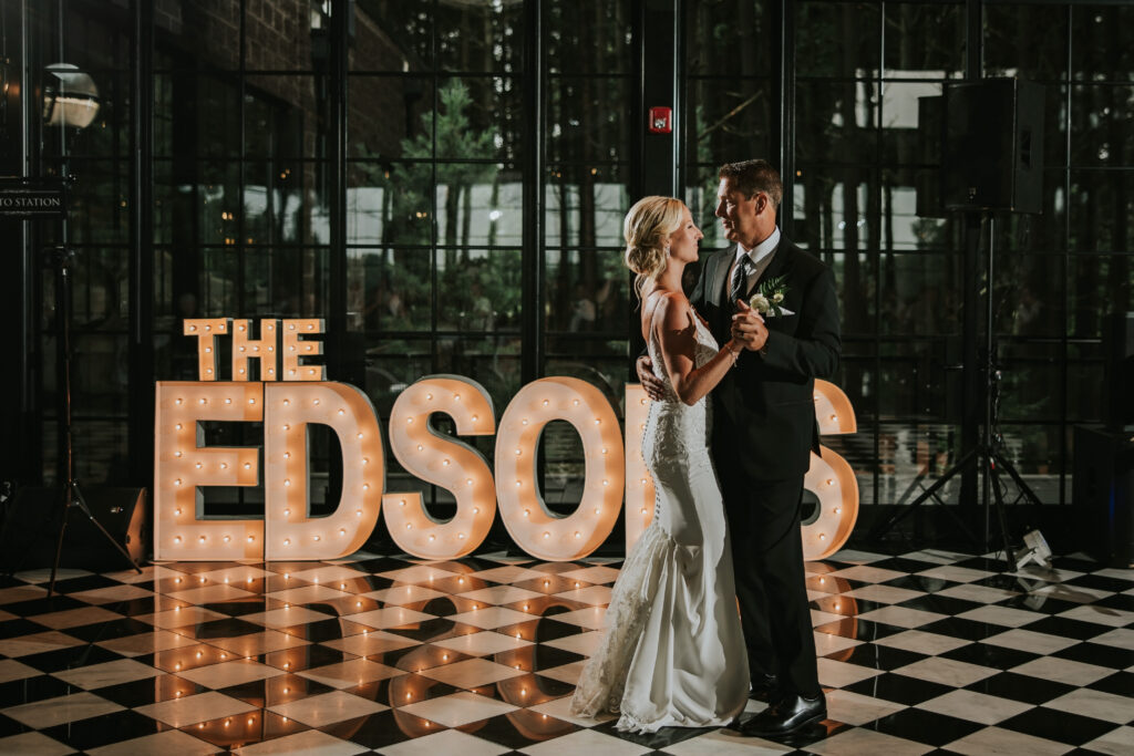 Bride and groom sharing a first dance in front of marquee letters at their Shepherd's Hollow wedding | Shepherd's Hollow wedding photography