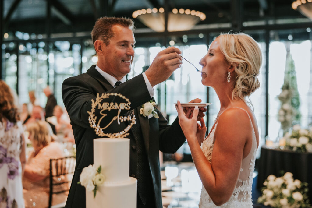 Bride and groom sharing a bite of their wedding cake at their Shepherd's Hollow wedding