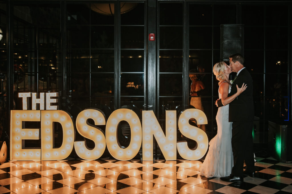 Bride and Groom kissing beside their marquee letter sign | Shepherd's Hollow wedding photography