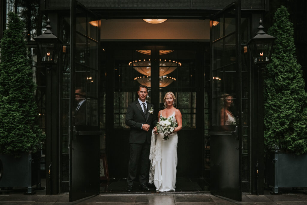 Bride and Groom looking at the camera in front of the main black doors | Shepherd's Hollow wedding photography