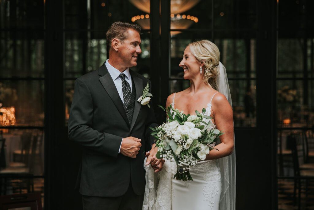 Bride and Groom smiling at one another at their Shepherd's Hollow wedding