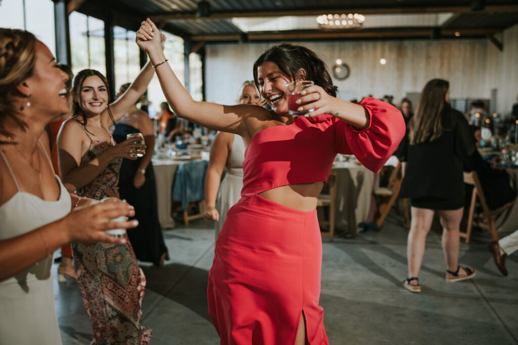 Wedding guests dancing in barn, celebratory vibes in Traverse City.