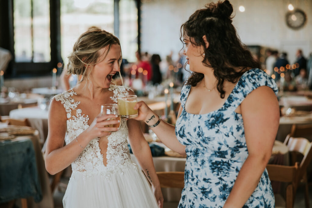 Bride sharing a toast with a friend at her Jacob's Farm Traverse City wedding